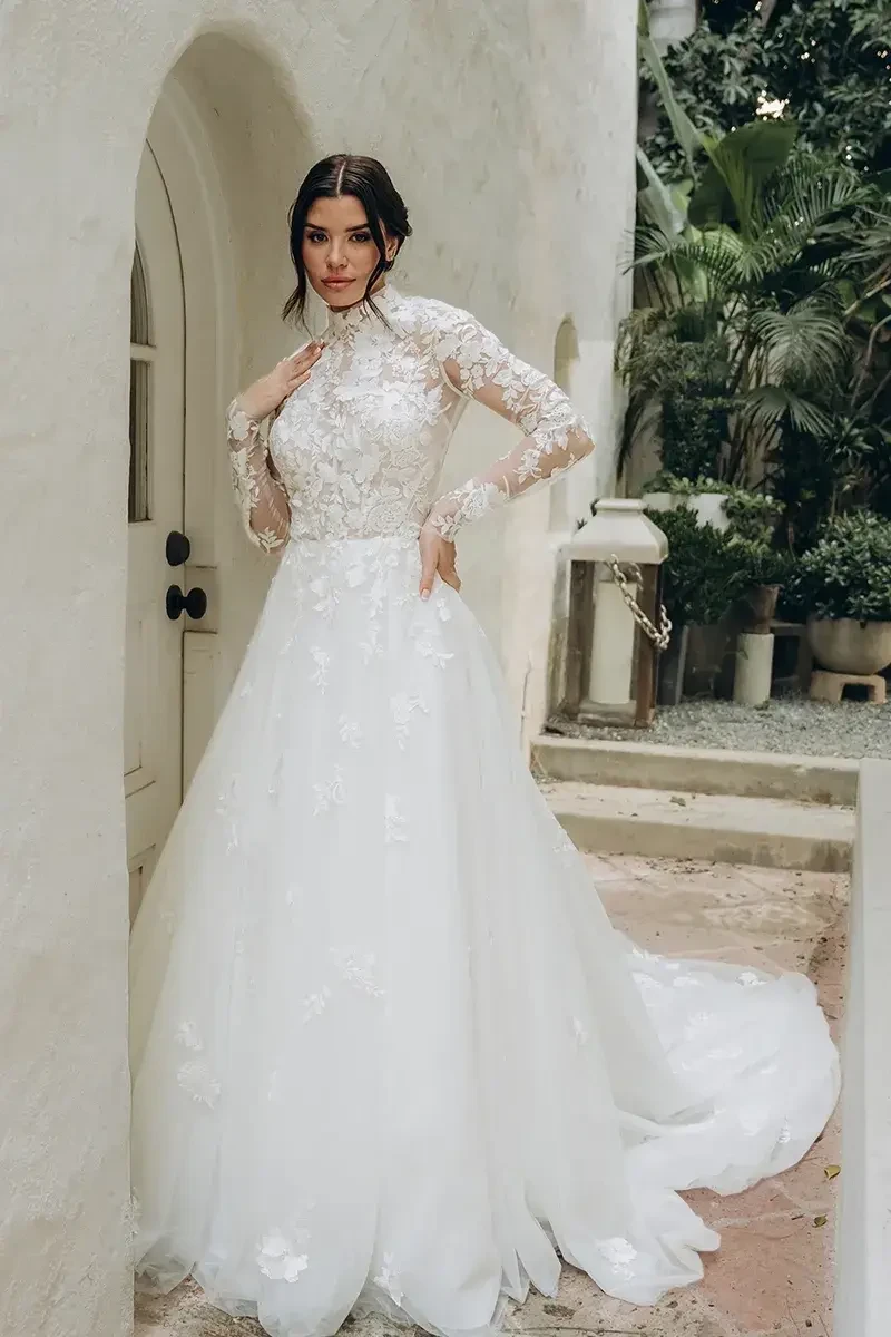 model is wearing a high neck long sleeve a-line wedding dress